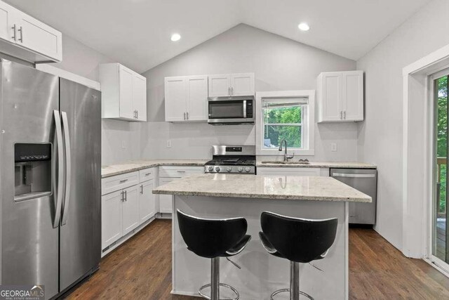2025 Venetian Dr SW, Atlanta, GA 30311 - kitchen with stainless steel appliances, a sink, white cabinetry, vaulted ceiling, and a center island