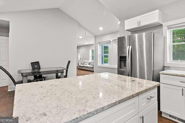 2025 Venetian Dr SW, Atlanta, GA 30311 - kitchen with stainless steel fridge with ice dispenser, vaulted ceiling, dark wood-type flooring, white cabinets, and light stone counters