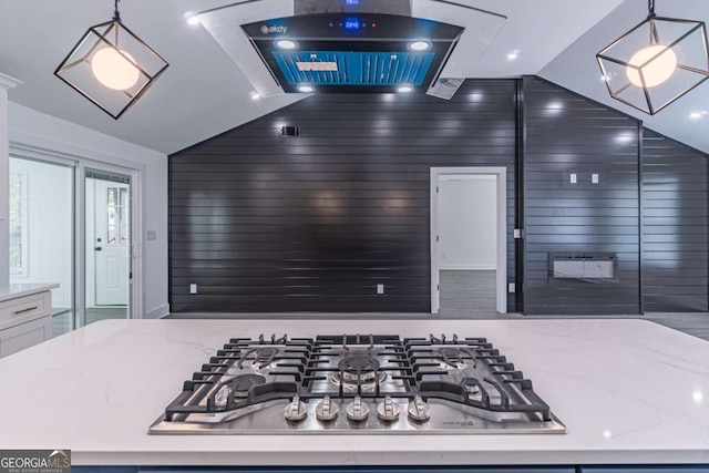 2265 Hillbriar Dr, Buford, GA 30518 - kitchen with stainless steel gas cooktop, lofted ceiling, hanging light fixtures, light stone counters, and ventilation hood