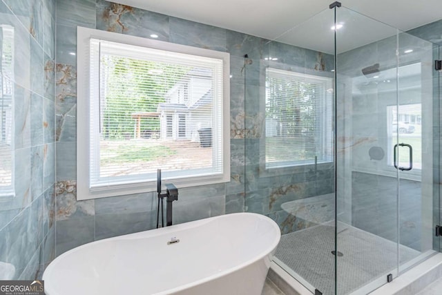 2265 Hillbriar Dr, Buford, GA 30518 - bathroom featuring tile walls, a stall shower, and a soaking tub