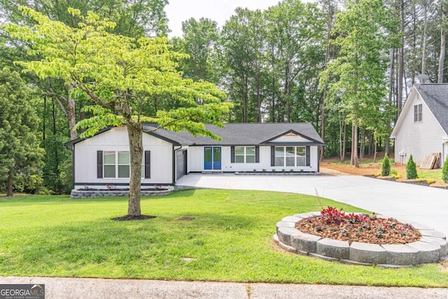 2265 Hillbriar Dr, Buford, GA 30518 - view of front facade with concrete driveway, a front yard, view of scattered trees, and board and batten siding