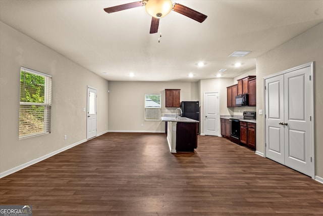 kitchen with black appliances, dark wood-style flooring, open floor plan, plenty of natural light, and recessed lighting