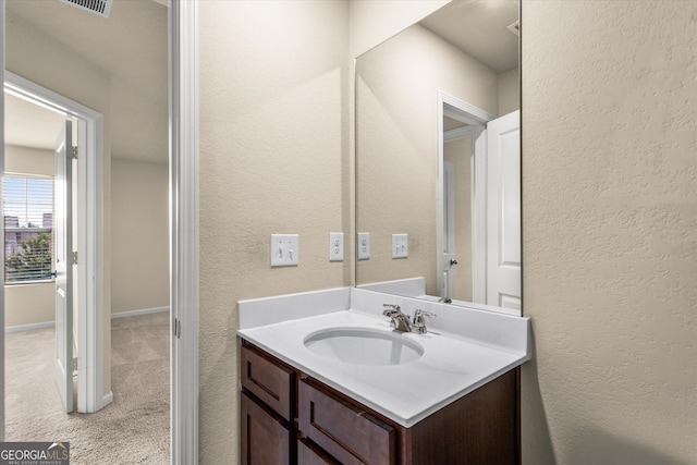 bathroom featuring vanity and a textured wall