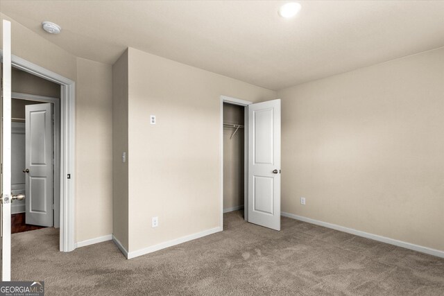 unfurnished bedroom featuring carpet, baseboards, and a closet