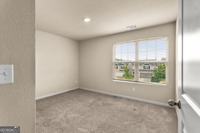 carpeted spare room featuring baseboards