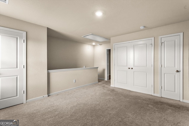 unfurnished bedroom with attic access, carpet, baseboards, recessed lighting, and a closet
