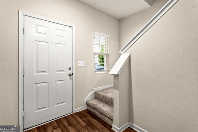entrance foyer with dark wood finished floors, stairs, and baseboards