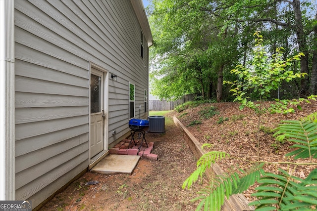 view of side of home with fence and cooling unit