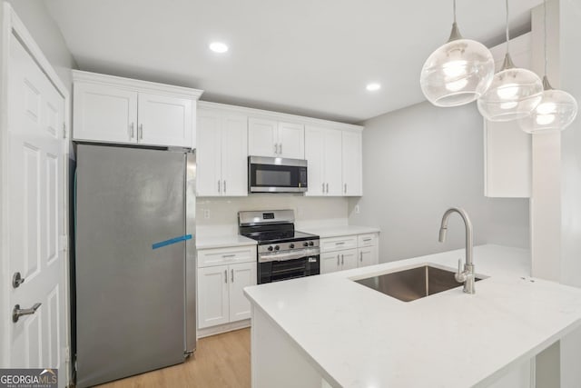 kitchen with appliances with stainless steel finishes, a sink, white cabinetry, and recessed lighting