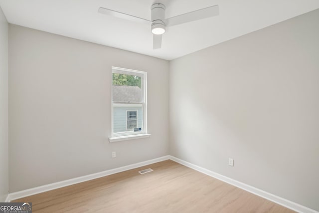 empty room with light wood finished floors, baseboards, and a ceiling fan