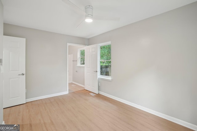 empty room featuring a ceiling fan, wood finished floors, and baseboards