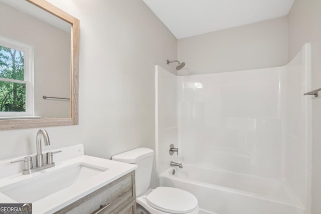 bathroom with toilet, vanity, and shower / washtub combination