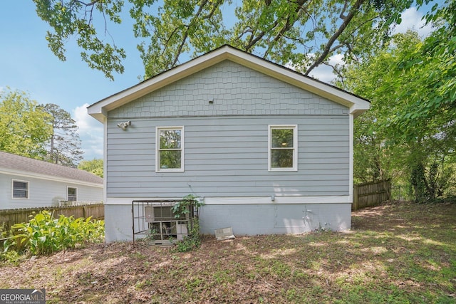 view of side of home featuring fence and crawl space