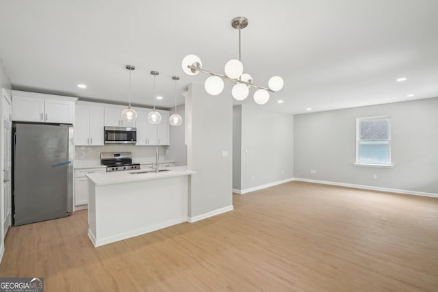 kitchen featuring stainless steel appliances, light wood-style floors, white cabinets, light countertops, and recessed lighting