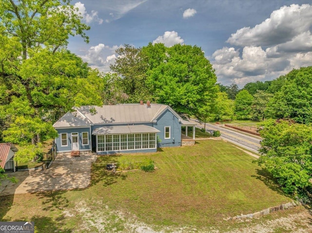 back of house featuring a sunroom and a lawn