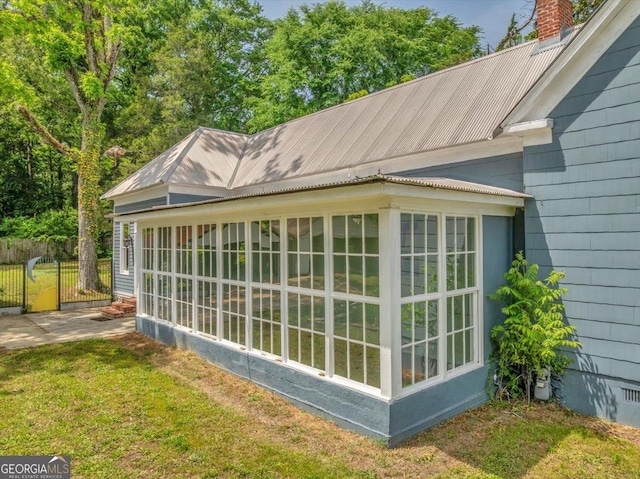 view of side of home with a sunroom and a chimney
