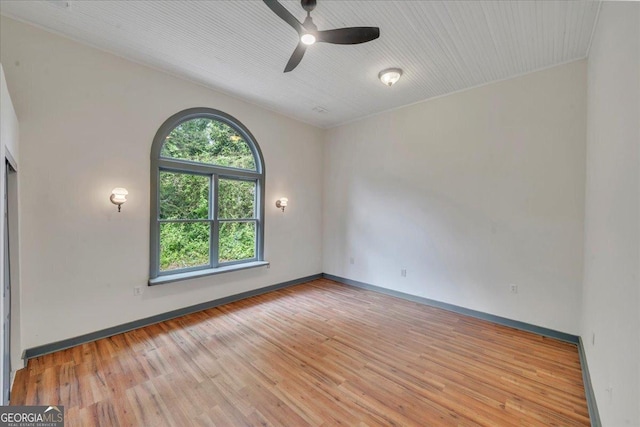 unfurnished room with wood finished floors, ceiling fan, and baseboards