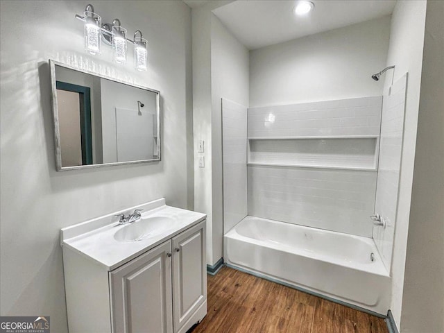 bathroom featuring wood finished floors, shower / washtub combination, and vanity