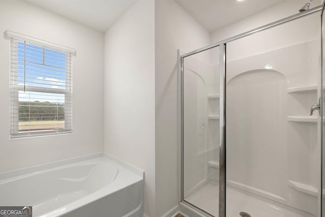 bathroom with a shower stall and a bath