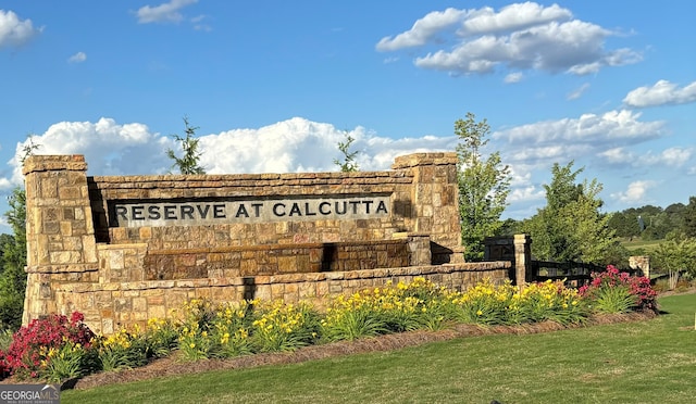 community / neighborhood sign featuring a yard