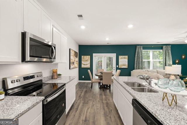 kitchen with appliances with stainless steel finishes, a sink, white cabinets, dark wood-style floors, and recessed lighting