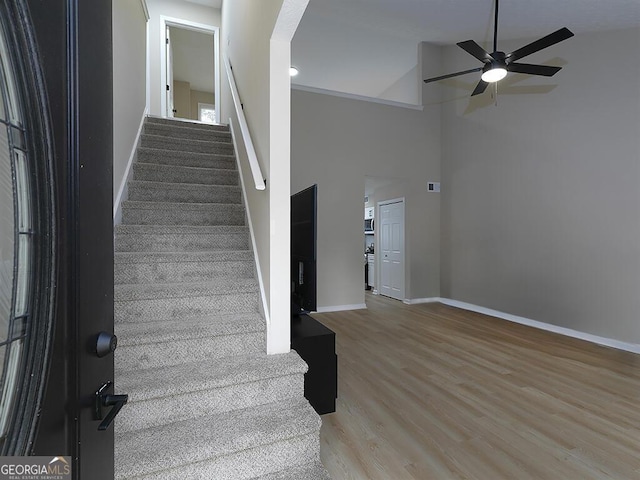 201 Twin Pines Ct, Dallas, GA 30132 - stairs with a ceiling fan, wood finished floors, arched walkways, baseboards, and high vaulted ceiling