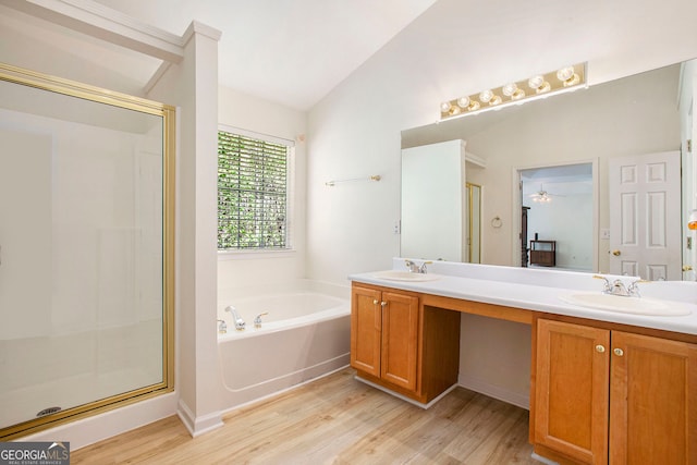 4535 Howell Farms Rd NW, Acworth, GA 30101 - bathroom featuring wood finished floors, a garden tub, a stall shower, double vanity, and vaulted ceiling