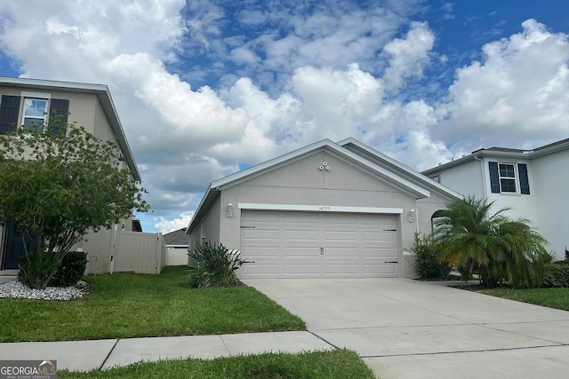 view of front of property with stucco siding, concrete driveway, an attached garage, and a gate