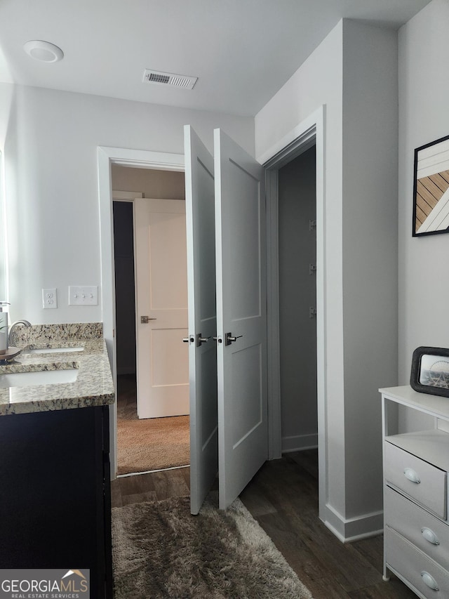 bathroom featuring wood finished floors, vanity, and baseboards