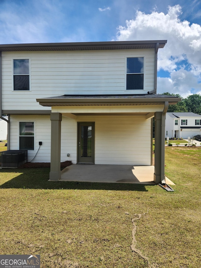rear view of house with a patio, a yard, and cooling unit