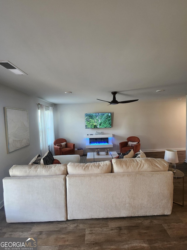 living room featuring dark wood finished floors and a ceiling fan