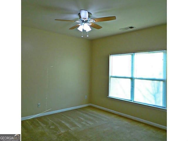 spare room with baseboards, carpet floors, and ceiling fan