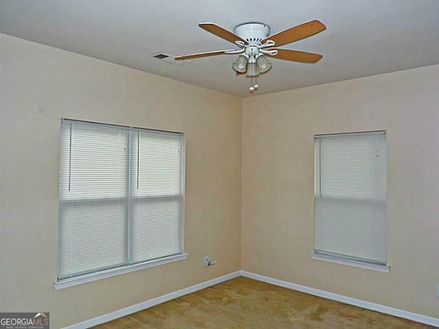 empty room with a ceiling fan, carpet, and baseboards