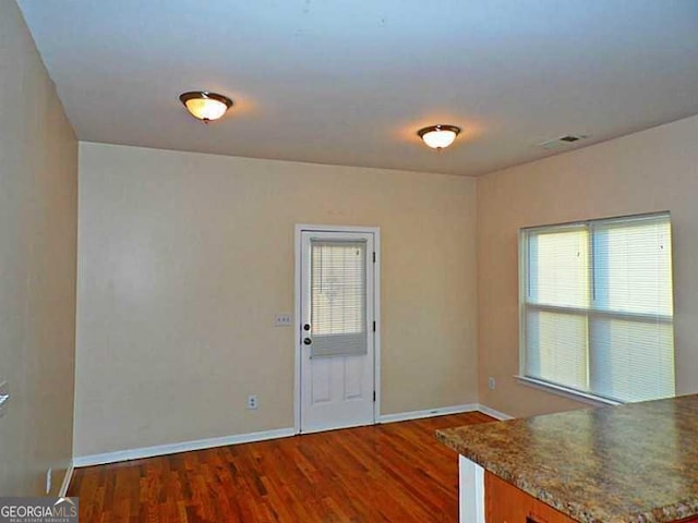 unfurnished room with wood finished floors and baseboards