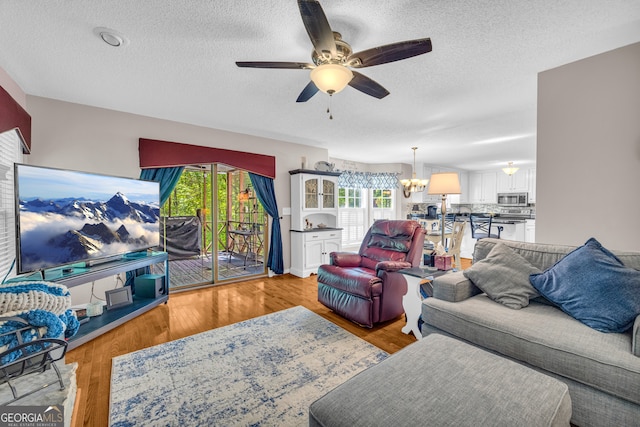 1886 Bend N Hickory Rd, Toccoa, GA 30577 - living area with ceiling fan, a textured ceiling, a chandelier, and light wood-style flooring
