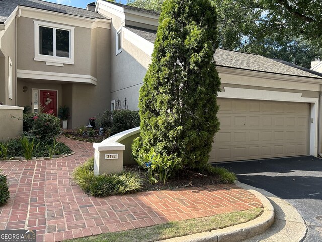 3192 Paces Mill Rd SE, Atlanta, GA 30339 - view of front of home featuring asphalt driveway, stucco siding, roof with shingles, and an attached garage