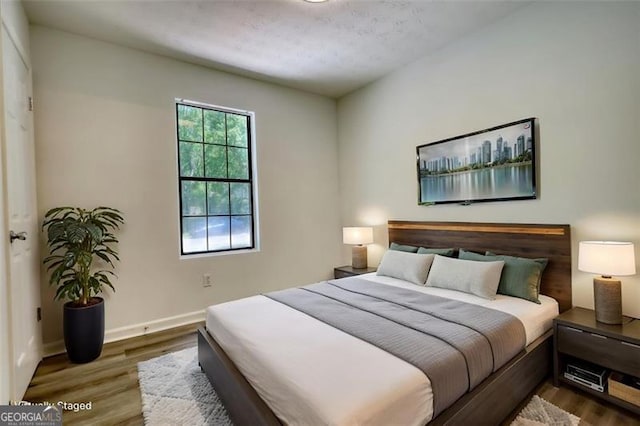 bedroom with wood finished floors and baseboards