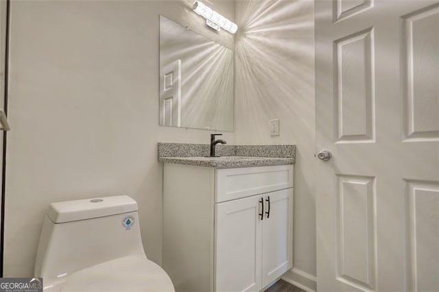 half bathroom featuring vanity and toilet