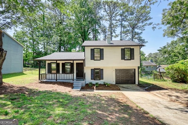 tri-level home with covered porch, driveway, an attached garage, and a chimney
