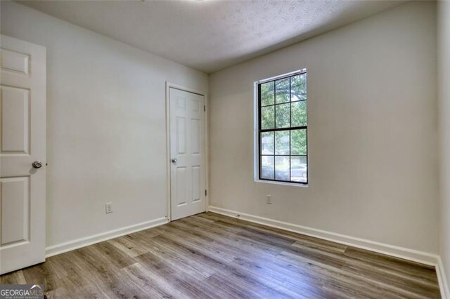 3959 Wood Path Dr, Stone Mountain, GA 30083 - unfurnished bedroom with wood finished floors and baseboards
