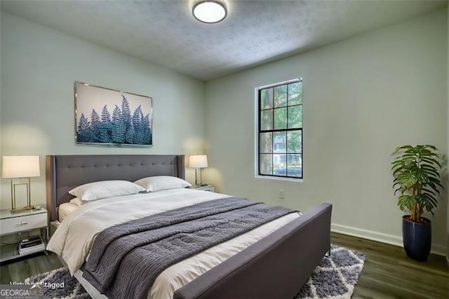 bedroom with wood finished floors and baseboards