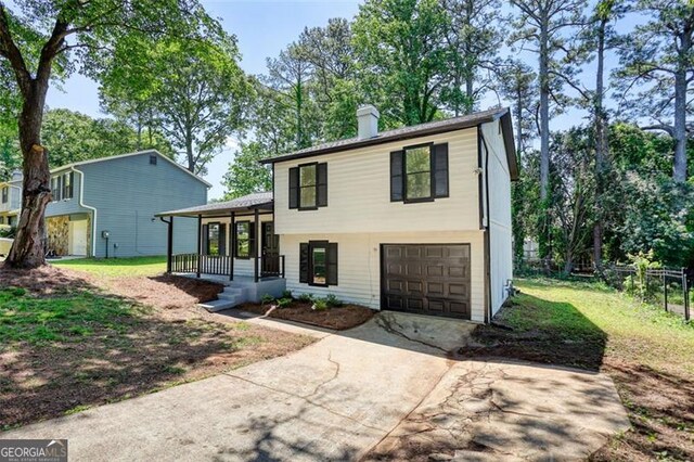 3959 Wood Path Dr, Stone Mountain, GA 30083 - split level home with a porch, a garage, concrete driveway, and a chimney
