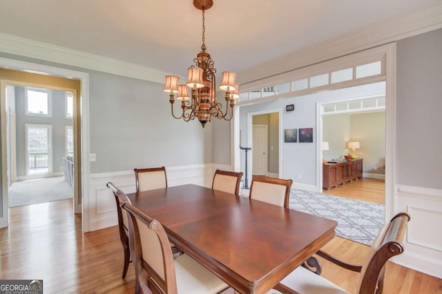 1608 Mulberry Lake Dr, Dacula, GA 30019 - dining area featuring a chandelier, light wood-style floors, crown molding, and a wainscoted wall