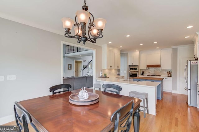 1608 Mulberry Lake Dr, Dacula, GA 30019 - dining space featuring stairway, a chandelier, recessed lighting, and light wood-style flooring