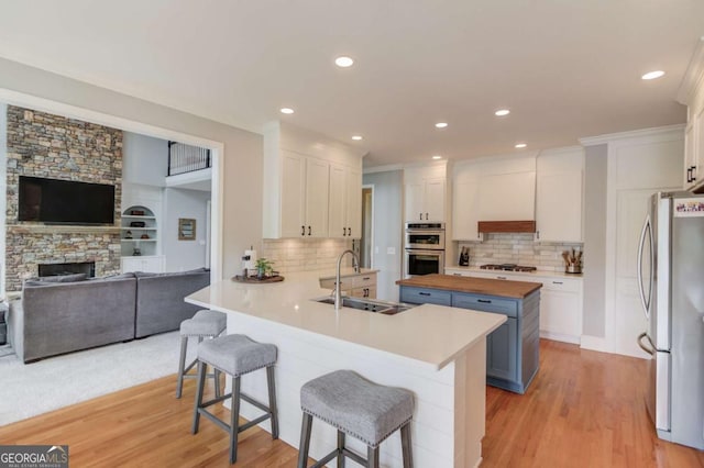 1608 Mulberry Lake Dr, Dacula, GA 30019 - kitchen featuring a sink, wooden counters, stainless steel appliances, white cabinetry, and recessed lighting