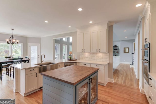 1608 Mulberry Lake Dr, Dacula, GA 30019 - kitchen featuring wood counters, a sink, light wood-type flooring, healthy amount of natural light, and ornamental molding