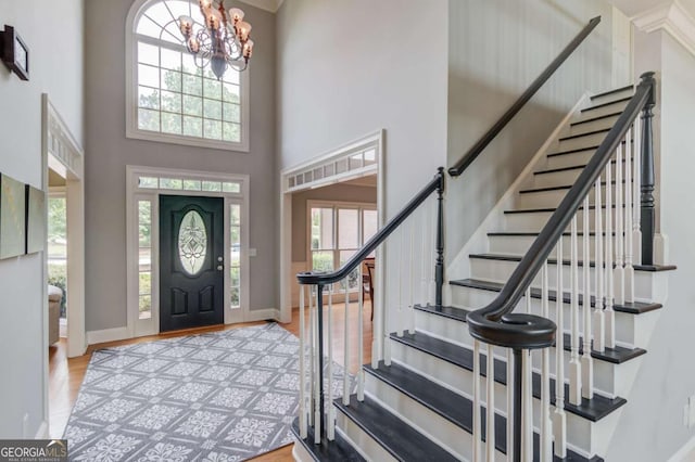 1608 Mulberry Lake Dr, Dacula, GA 30019 - entrance foyer with healthy amount of natural light, a chandelier, stairway, wood finished floors, and a high ceiling
