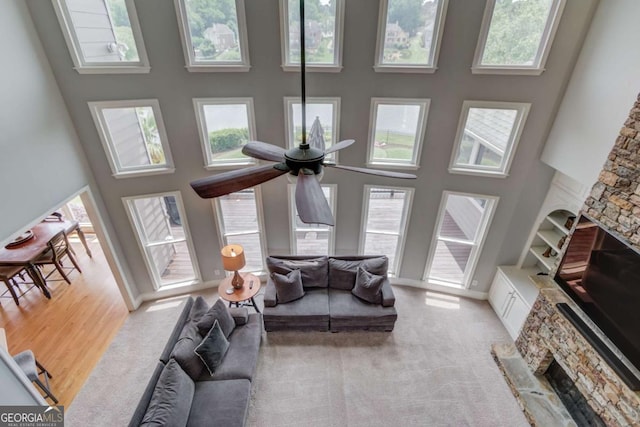 1608 Mulberry Lake Dr, Dacula, GA 30019 - living area featuring a towering ceiling, a fireplace, ceiling fan, and light colored carpet