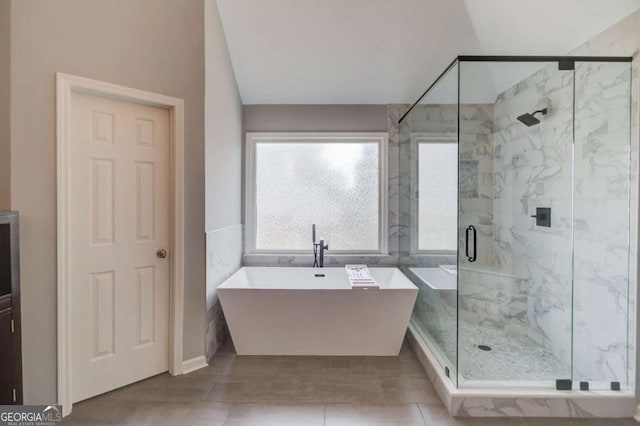 1608 Mulberry Lake Dr, Dacula, GA 30019 - full bath with a marble finish shower, vaulted ceiling, a freestanding tub, tile walls, and tile patterned flooring