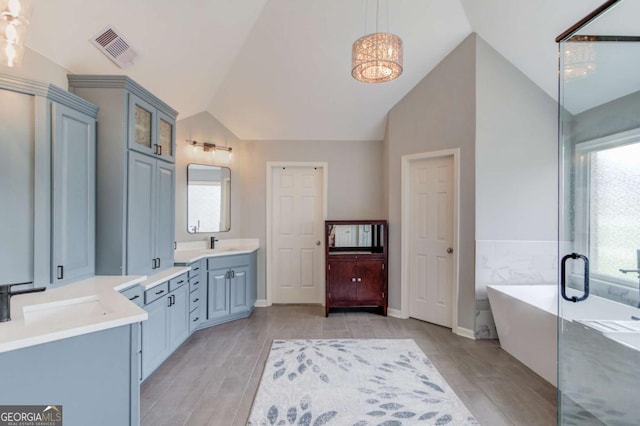 1608 Mulberry Lake Dr, Dacula, GA 30019 - full bathroom featuring vaulted ceiling, wood finished floors, a soaking tub, and vanity